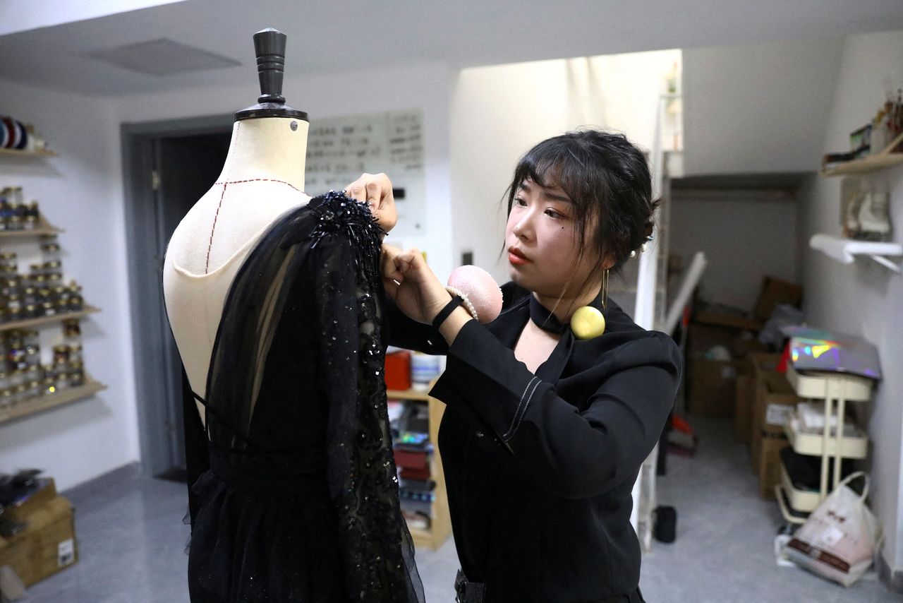 Costume designer Zhang Yifan works on a skating outfit she designed for her sister, figure skating athlete Zhang Yixuan, at her studio in Beijing, China December 7, 2021. REUTERS/Tingshu Wang