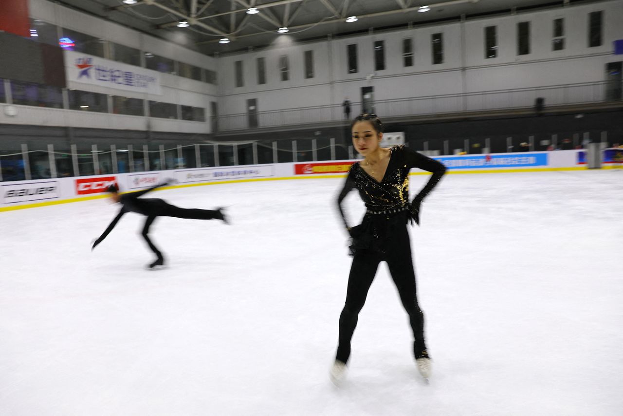 Figure skating athlete Zhang Yixuan skates as she wears a skating outfit newly-made by her sister, costume designer Zhang Yifan, during a training session at an ice rink in Beijing, China December 11, 2021.REUTERS/Tingshu Wang