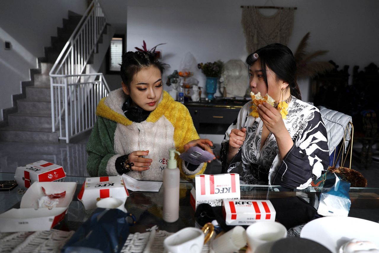 Costume designer Zhang Yifan has lunch as she chats with her sister, figure skating athlete Zhang Yixuan, after a training session, at her studio in Beijing, China December 11, 2021. REUTERS/Tingshu Wang