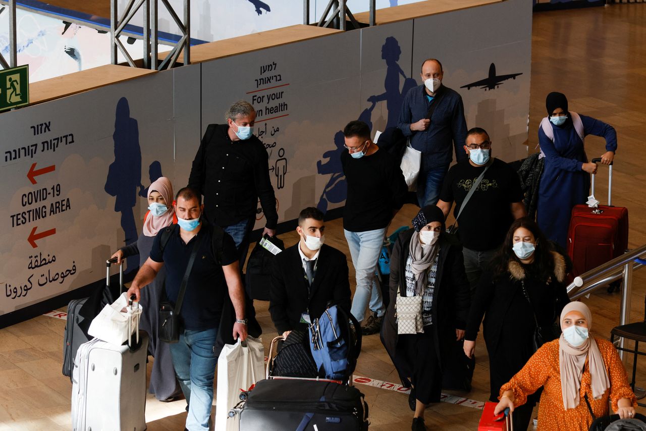 FILE PHOTO: Travellers walk towards the coronavirus disease (COVID-19) pandemic testing area at Ben Gurion International Airport as Israel imposes new restrictions near Tel Aviv, Israel November 28, 2021. REUTERS/Amir Cohen