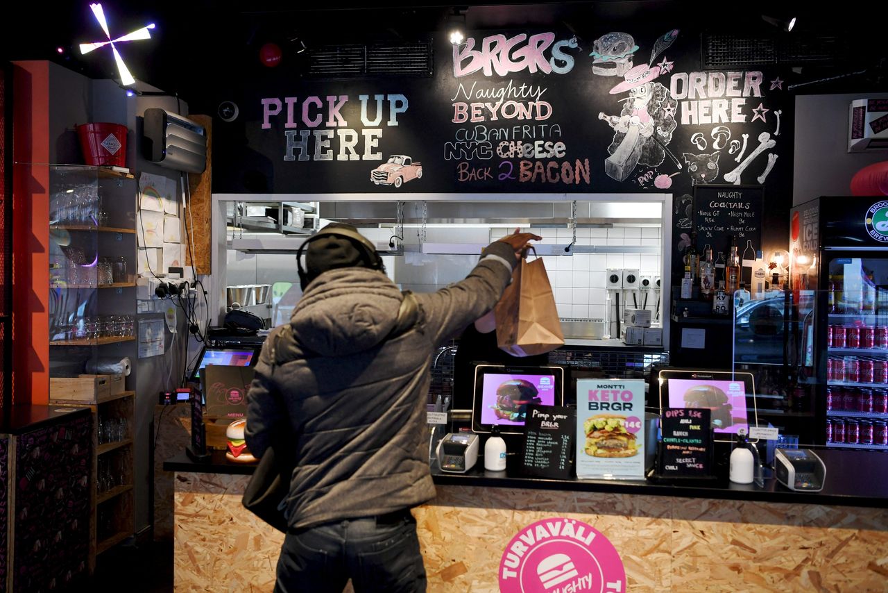 FILE PHOTO: A customer collects takeaway food from the Naughty BRGR restaurant, as the three weeks long partial lockdown of the restaurants starts due to the coronavirus disease (COVID-19) pandemic, in Helsinki, Finland March 8, 2021. Lehtikuva/Antti Aimo-Koivisto via REUTERS