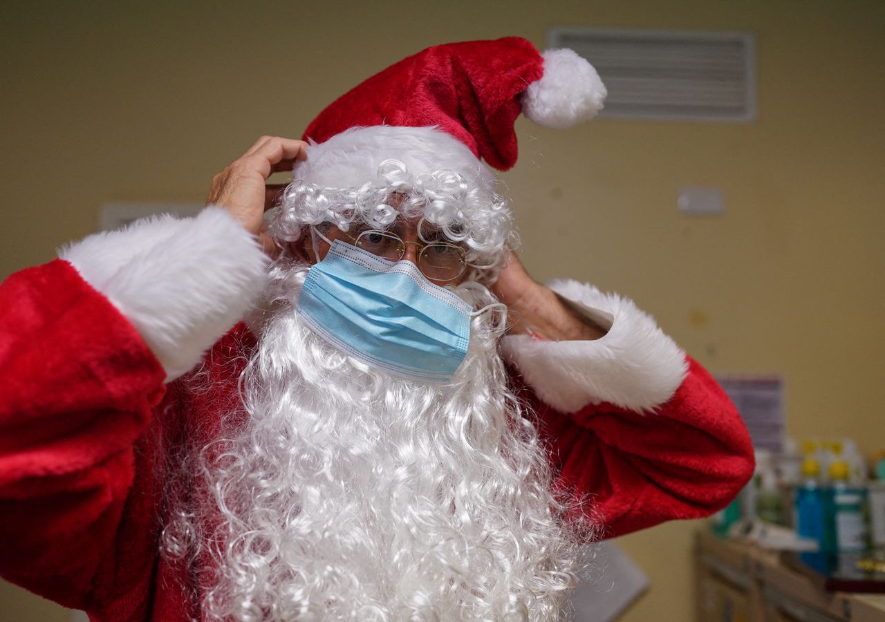 FILE PHOTO: Pastor David Shrimpton, 57, known as the "flying padre" puts on a protective face mask with his Santa Claus costume before speaking to young students about Christmas at School of the Air in Broken Hill, Australia, December 8, 2021. REUTERS/Loren Elliott