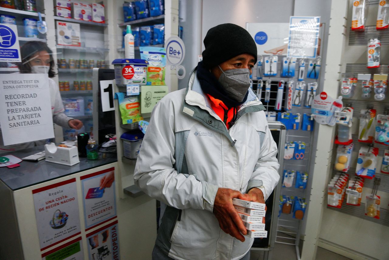 A person leaves after receiving free lateral flow coronavirus disease (COVID-19) test kits at a pharmacy, as the regional authorities re-stocked the supplies after the Christmas in Madrid, Spain December 28, 2021. REUTERS/Javier Barbancho