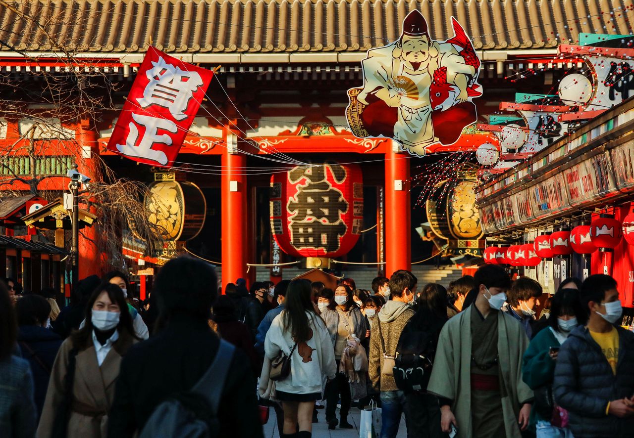 FILE PHOTO: Visitors wearing protective face masks walk under decorations for the New Year at Nakamise street leading to Senso-ji temple at Asakusa district, a popular sightseeing spot, amid the coronavirus disease (COVID-19) pandemic, in Tokyo, Japan, December 24, 2021.  REUTERS/Issei Kato
