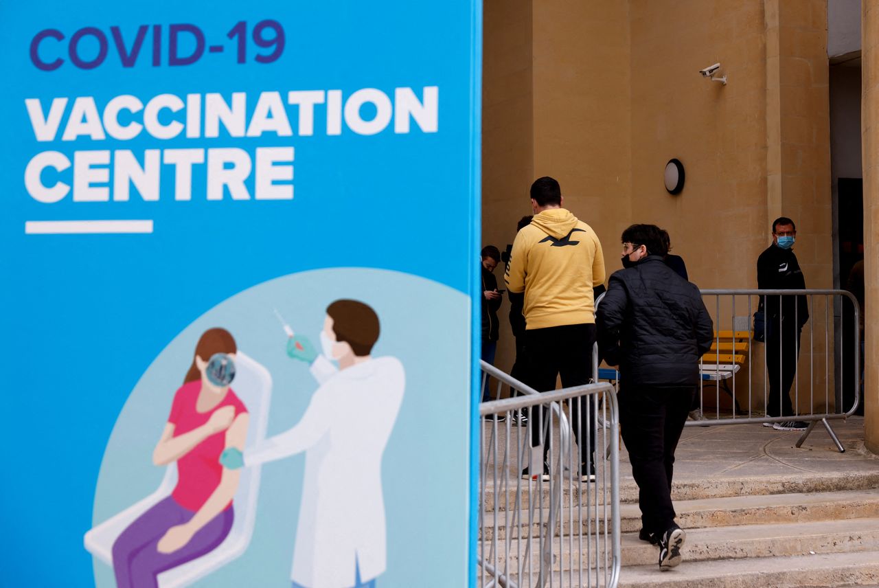 People wearing protective masks queue for booster injections of a coronavirus disease (COVID-19) vaccine as the pandemic continues, at a vaccination centre at the University of Malta in Tal-Qroqq, Malta December 29, 2021. REUTERS/Darrin Zammit Lupi