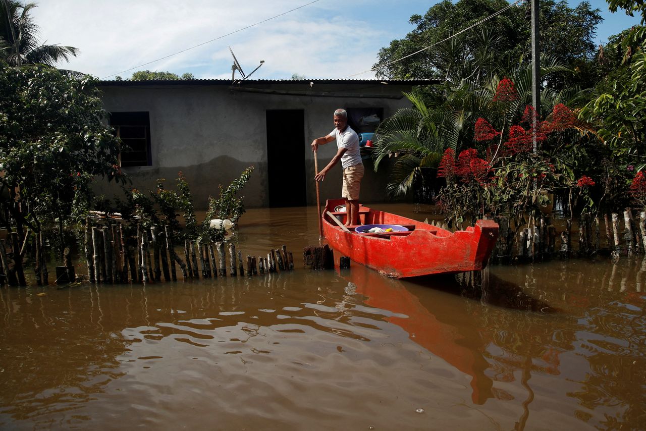 FILE PHOTO: Valfredo Alcantara Pereira, 55, uses a canoe to reach his partially submerged house in a flooded street, in Ilheus, Bahia state, Brazil December 30, 2021. REUTERS/Amanda Perobelli/File Photo