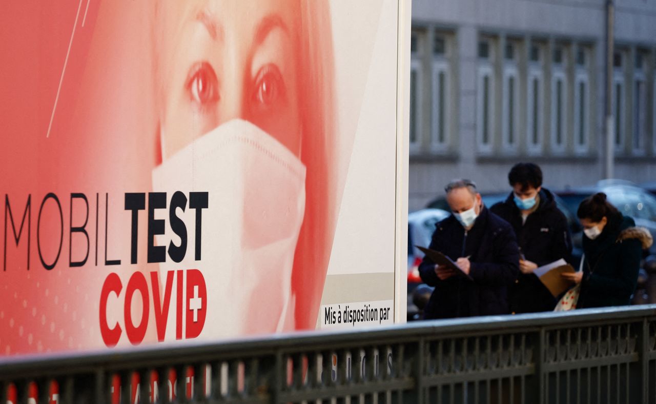 FILE PHOTO: People queue at a mobile coronavirus disease (COVID-19) testing booth in Paris, France, December 31, 2021. REUTERS/Christian Hartmann