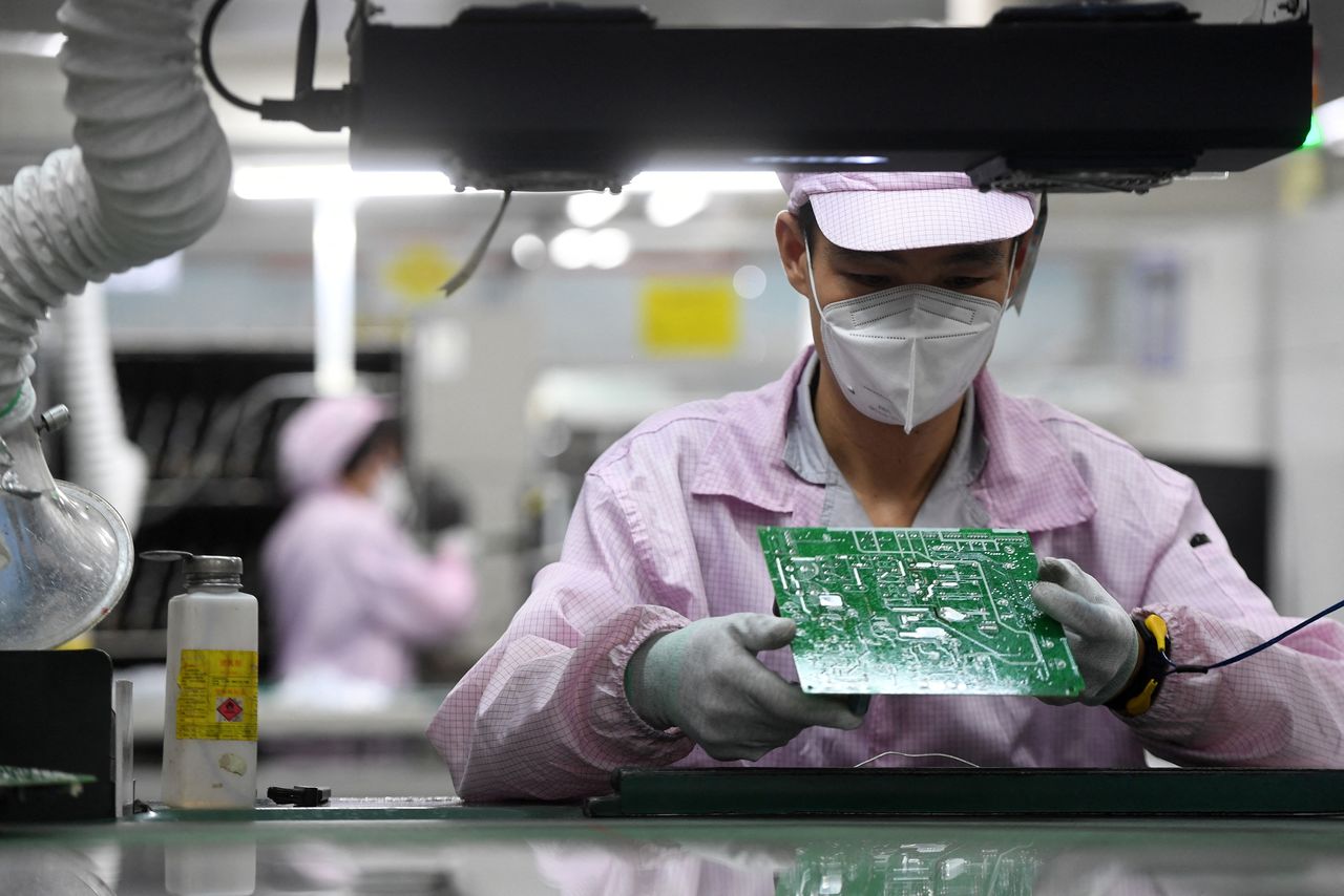 FILE PHOTO: An employee inspects a circuit board on the controller production line at a Gree factory, following the coronavirus disease (COVID-19) outbreak in Wuhan, Hubei province, China August 16, 2021. China Daily via REUTERS