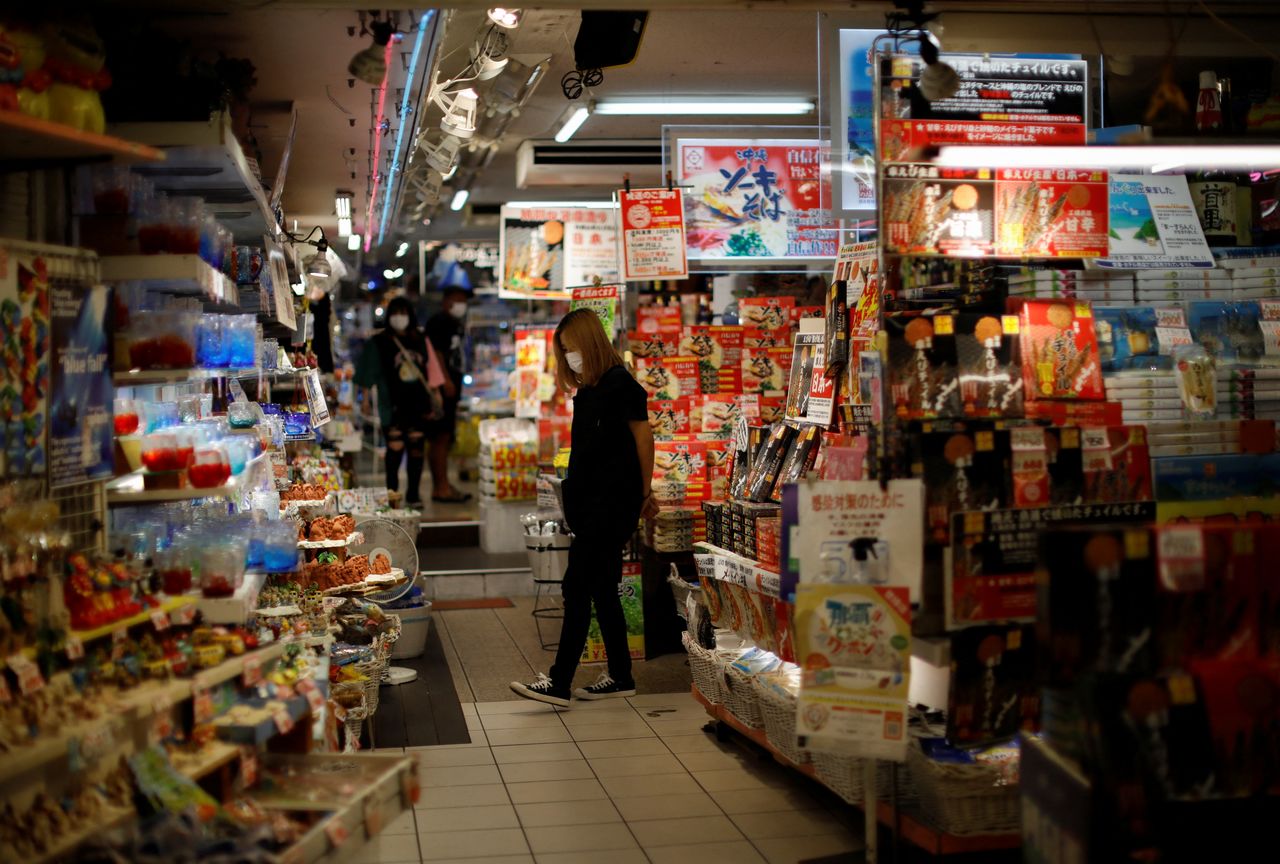 FILE PHOTO: Shoppers wearing protective face masks, amid the coronavirus disease (COVID-19) pandemic, are seen inside a souvenir shop along the Kokusai-dori in the prefectural capital Naha, on the southern island of Okinawa, Okinawa prefecture, Japan, October 24, 2021. REUTERS/Issei Kato