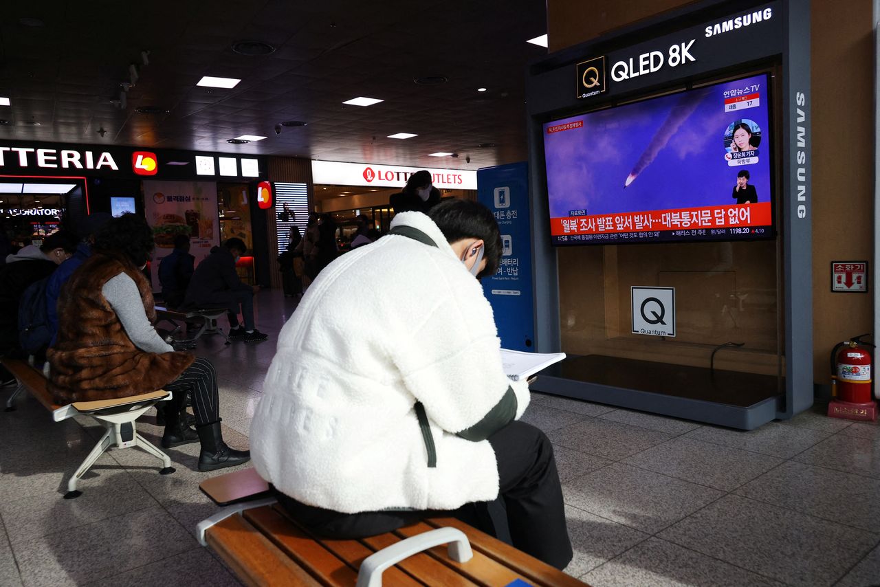 A man sits in front of a TV broadcasting file footage of a news report on North Korea firing a ballistic missile off its east coast, in Seoul, South Korea, January 5, 2022.   REUTERS/Kim Hong-Ji