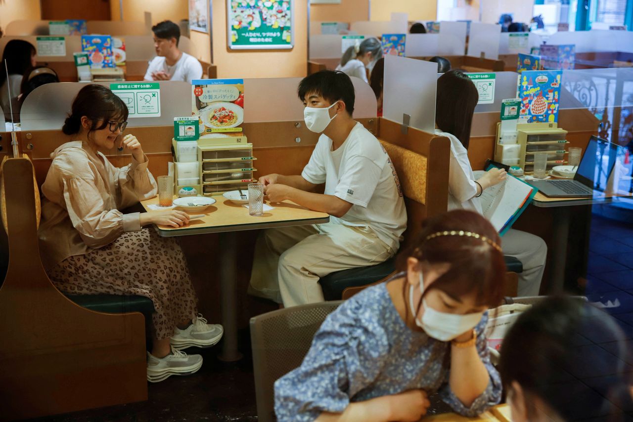 FILE PHOTO: People sit in a restaurant using plexiglass separators to protect customers from coronavirus (COVID-19) disease in the Shibuya area of Tokyo, Japan, July 29, 2021. REUTERS/Androniki Christodoulou