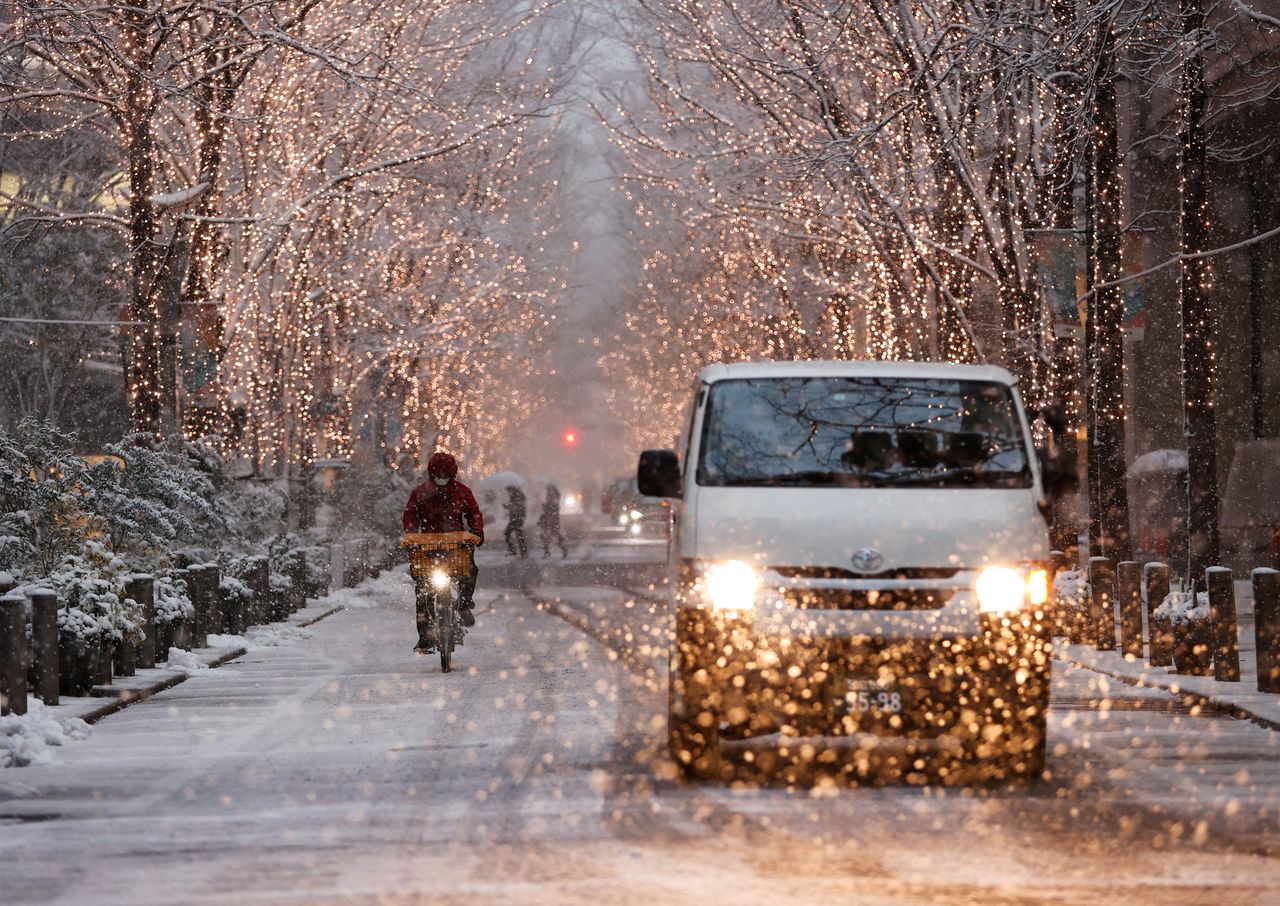 People drive on a street in the snowfall, amid the coronavirus disease (COVID-19) pandemic, in Tokyo, Japan January 6, 2022. REUTERS/Issei Kato
