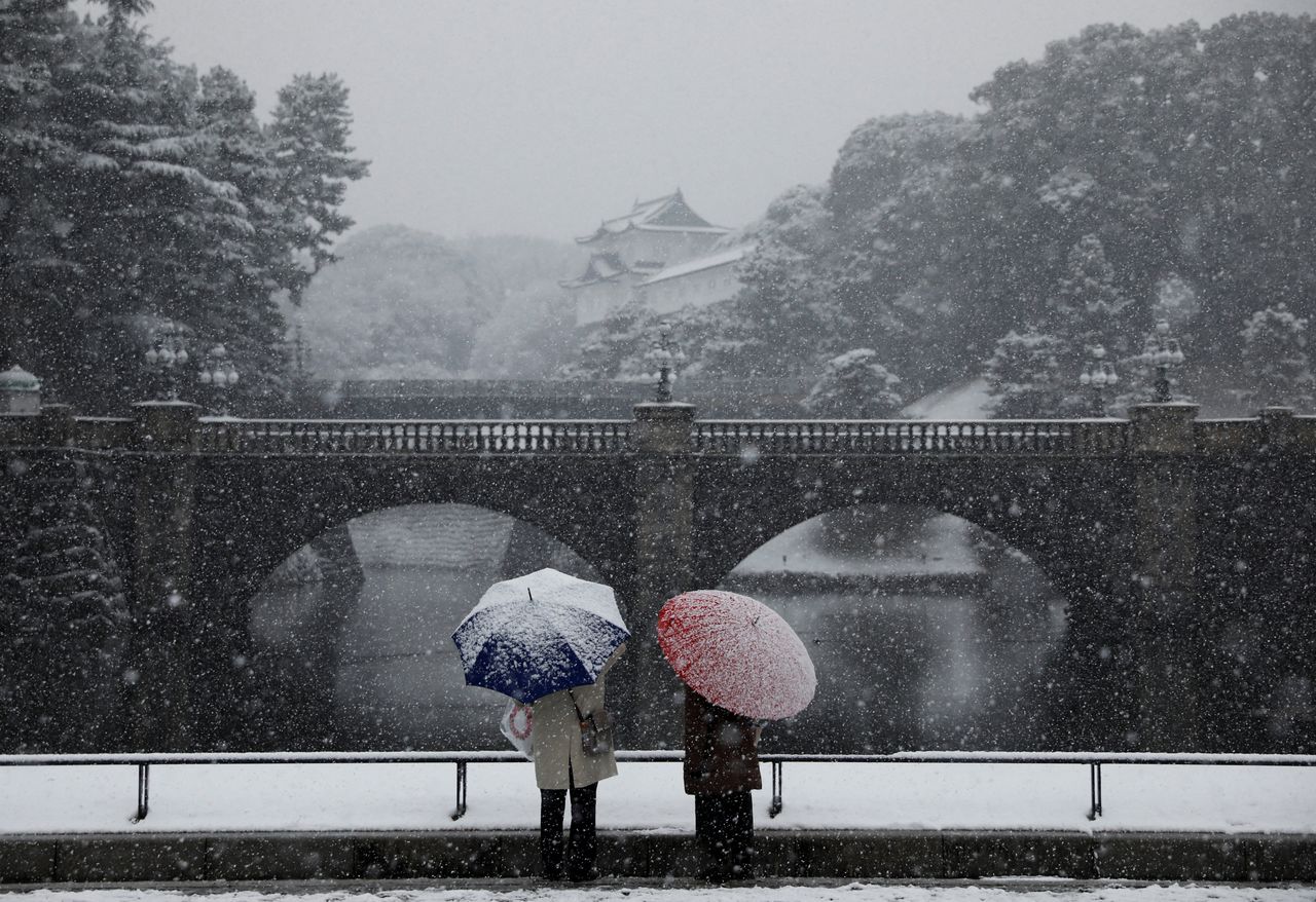 People look at the snow-covered Imperial Palace, amid the coronavirus disease (COVID-19) pandemic, in Tokyo, Japan January 6, 2022. REUTERS/Issei Kato
