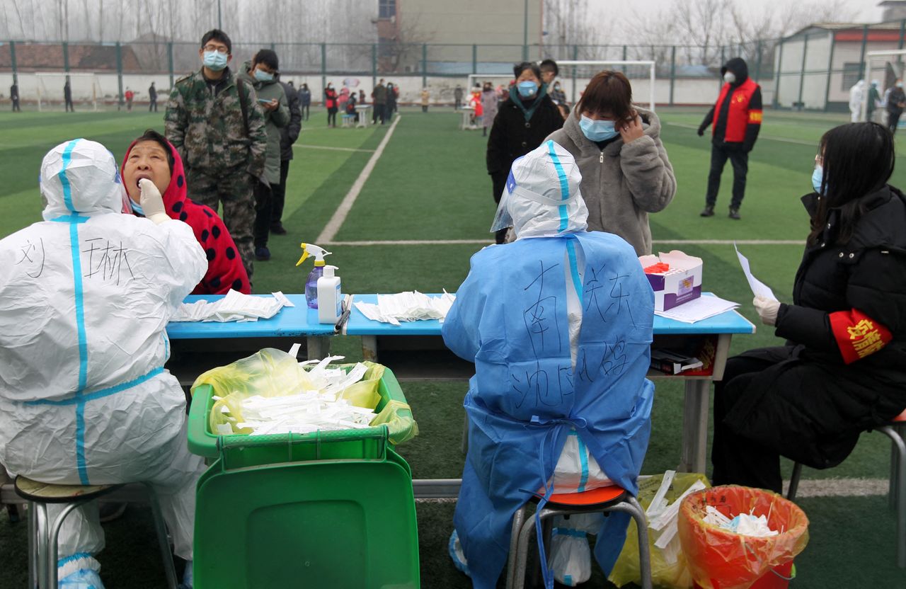 Residents line up for nucleic acid testing during a mass testing following cases of the coronavirus disease (COVID-19) in Xuchang, Henan province, China January 6, 2022. China Daily via REUTERS