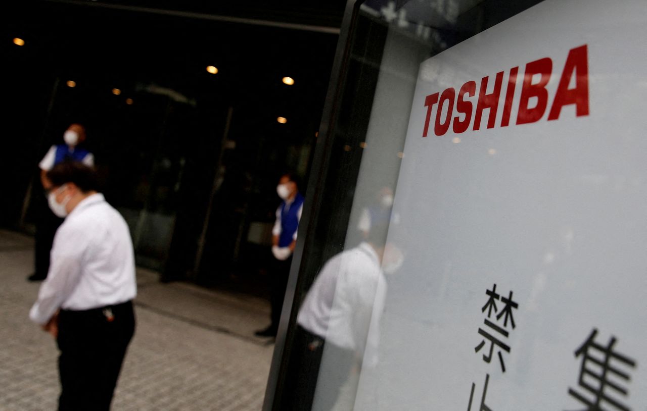FILE PHOTO: A staff member bows to a shareholder (not in picture) arriving a venue of Toshiba Corp