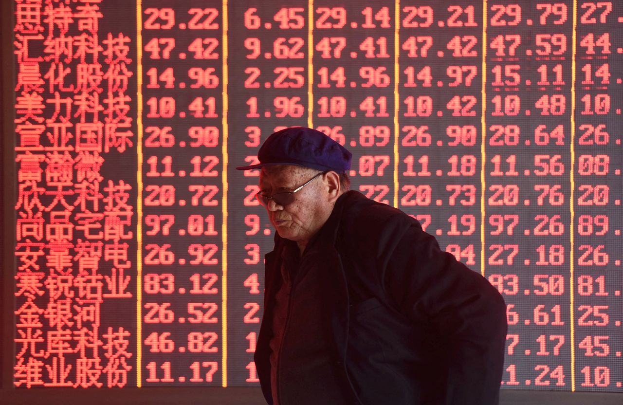 FILE PHOTO: A man stands in front of an electronic board displaying stock information at a brokerage firm in Hangzhou, Zhejiang province, China April 1, 2019. Picture taken April 1, 2019. REUTERS/Stringer