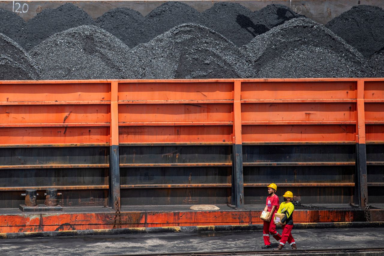 FILE PHOTO: Workers walk near a tugboat carrying coal barges at a port in Palembang, South Sumatra province, Indonesia, January 4, 2022, in this photo taken by Antara Foto. Antara Foto/Nova Wahyudi/ via REUTERS