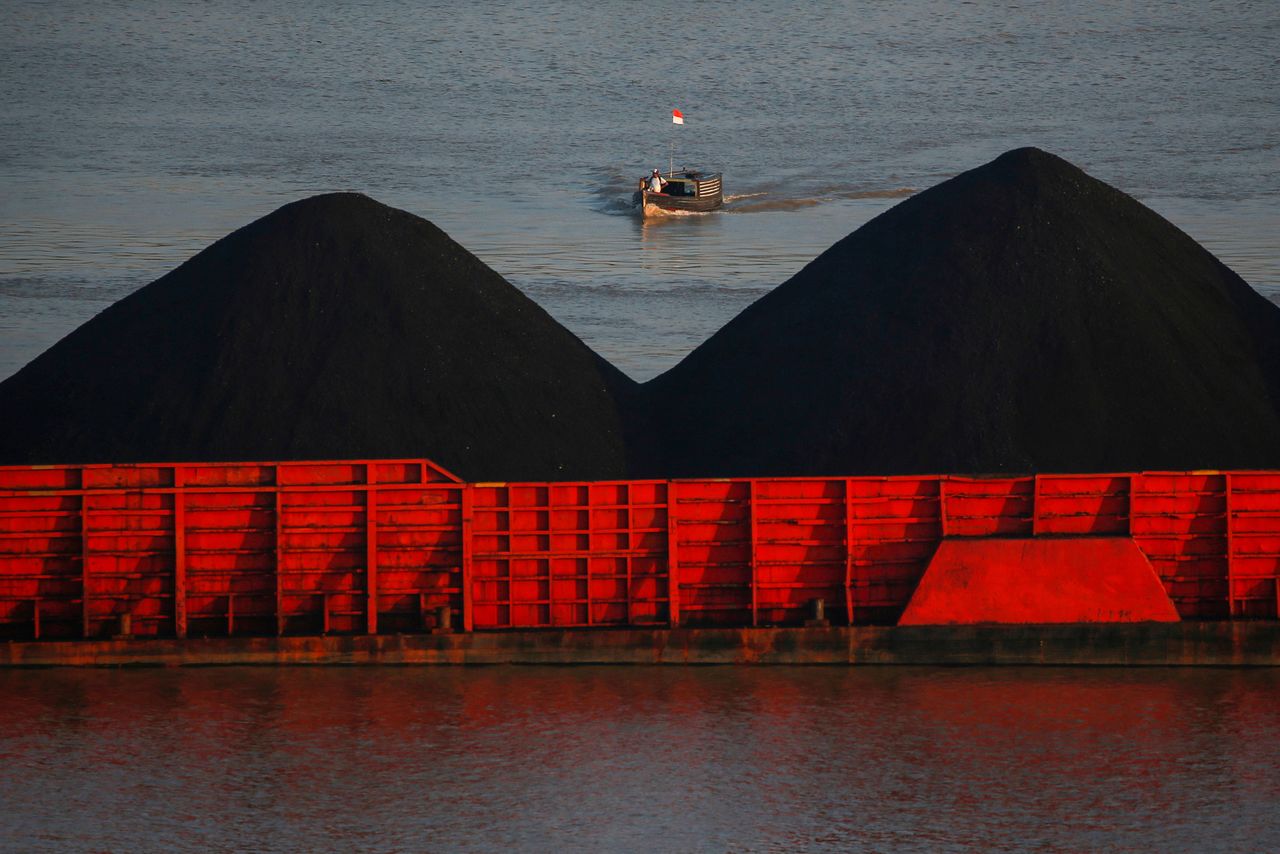 FILE PHOTO: A man stands on a boat as coal barges queue to be pulled along Mahakam river in Samarinda, East Kalimantan province, Indonesia, August 31, 2019. REUTERS/Willy Kurniawan