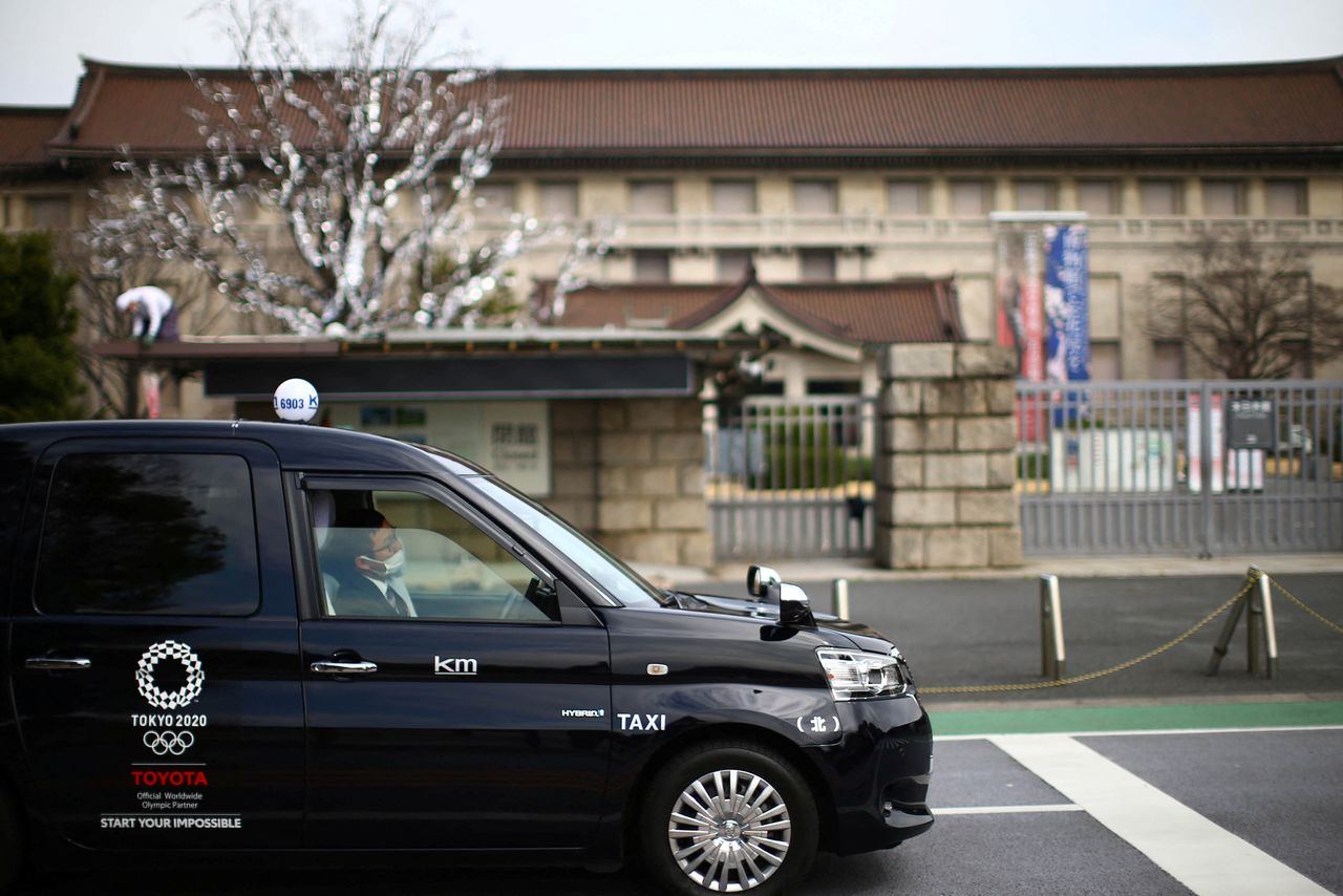 FILE PHOTO: A taxi driver, wearing protective face mask following an outbreak of the coronavirus disease (COVID-19), sits in a car outside Tokyo National Museum in Tokyo, Japan March 9, 2020. REUTERS/Edgard Garrido