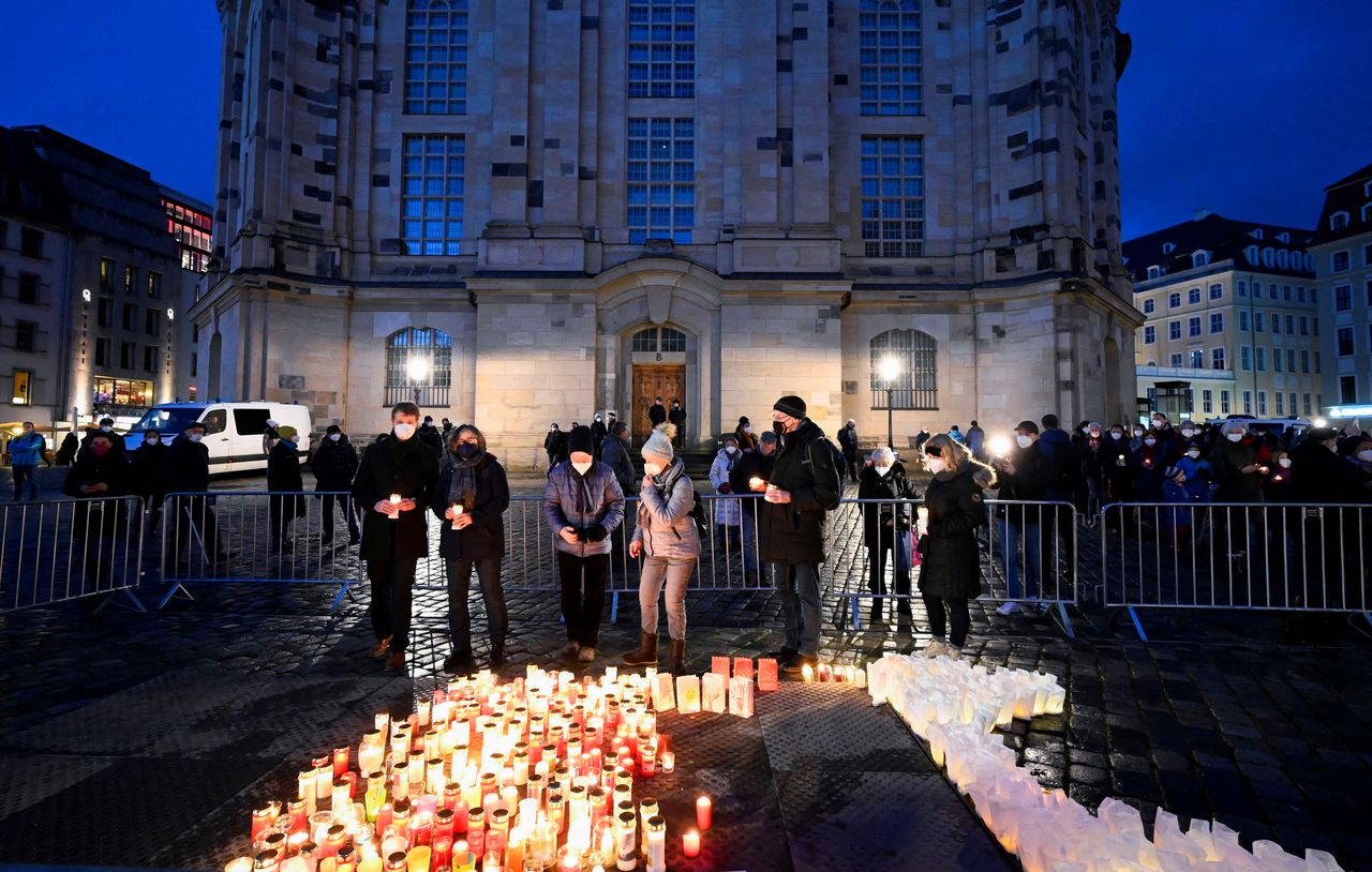 FILE PHOTO: People light candles at the Neumarkt square during a gathering called "Haltung zeigen" ("take up stance") to commemorate the victims of the coronavirus disease (COVID-19) pandemic in Dresden, Germany, January 8, 2022. REUTERS/Matthias Rietschel