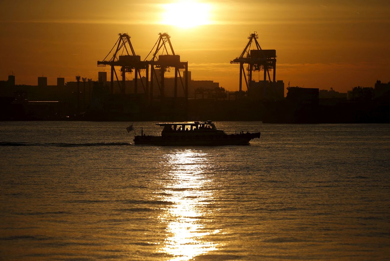 FILE PHOTO: A ship sails in front of cranes during sunset at a port in Tokyo, Japan, December 9, 2015. Picture taken December 9, 2015.   REUTERS/Toru Hanai/File Photo