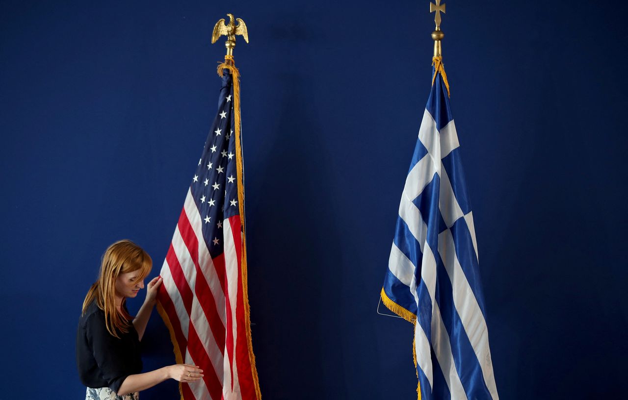 FILE PHOTO: A woman adjusts the U.S. flag ahead of U.S. Secretary of State Mike Pompeo