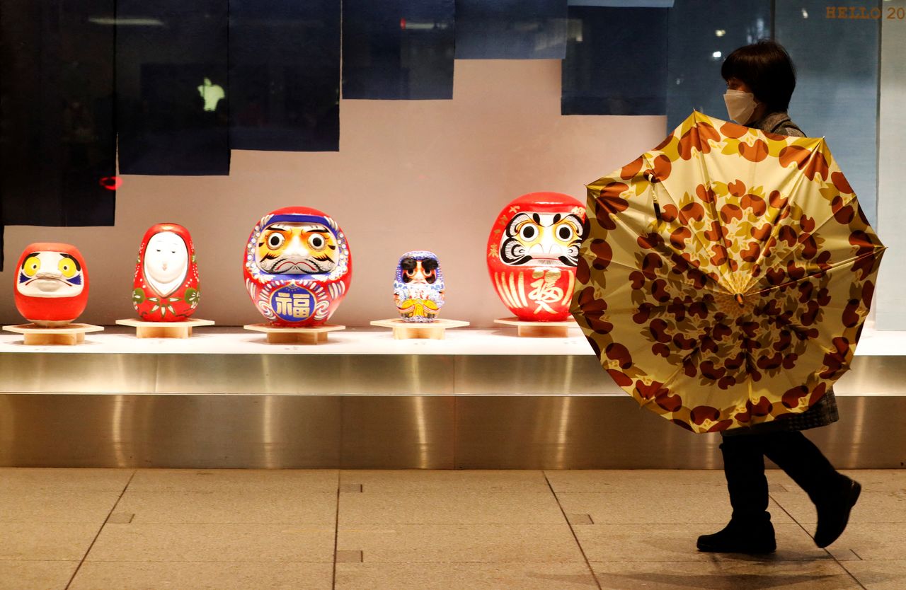 A woman wearing a protective face mask, amid the coronavirus disease (COVID-19) outbreak, walks past a display window of a department store in Tokyo, Japan, January 11, 2022. REUTERS/Kim Kyung-Hoon