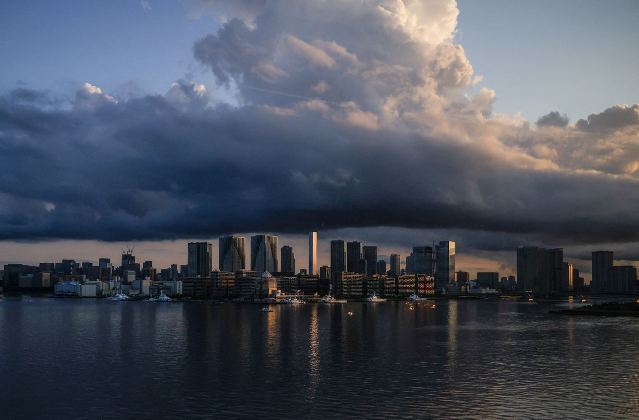 FILE PHOTO: City skyline and harbour are seen at sunrise from a quarantine bus window during the Tokyo 2020 Olympic Games in Tokyo, Japan July 24, 2021. REUTERS/Maxim Shemetov