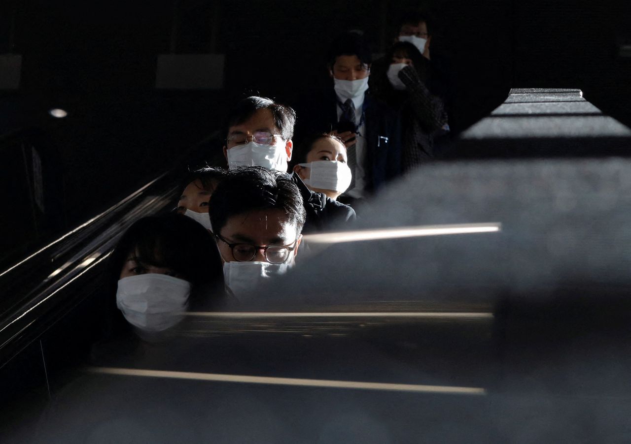FILE PHOTO: Passengers wearing protective face masks are pictured at a train station, amid the coronavirus disease (COVID-19) pandemic, in Tokyo, Japan, January 7, 2022. REUTERS/Issei Kato