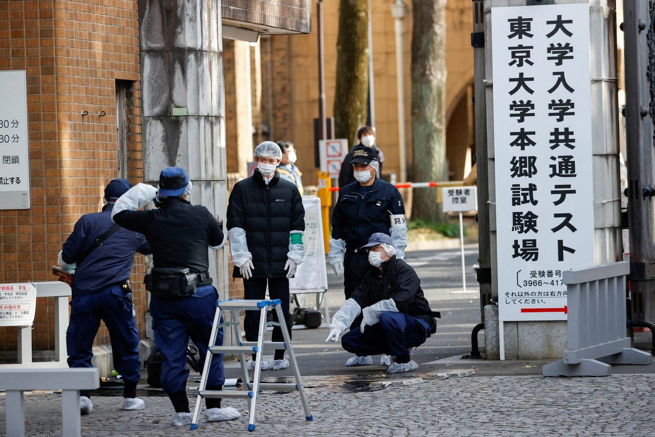 Police officers inspect the site where a stabbing incident happened at an entrance gate of Tokyo University in Tokyo, Japan January 15, 2022. REUTERS/Issei Kato