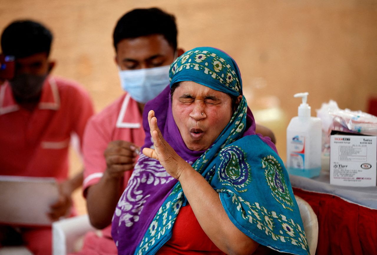 A woman reacts as she receives a dose of the COVISHIELD vaccine against the coronavirus disease (COVID-19), manufactured by Serum Institute of India, at a vaccination centre in Ahmedabad, India, December 27, 2021. REUTERS/Amit Dave TPX IMAGES OF THE DAY