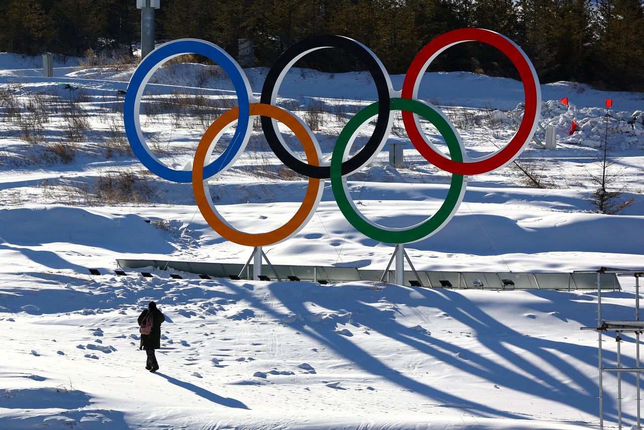 FILE PHOTO: A person walks past the Olympic rings in the Zhangjiakou competition zone ahead of the Beijing 2022 Winter Olympics in Beijing, China January 15, 2022. REUTERS/Pawel Kopczynski