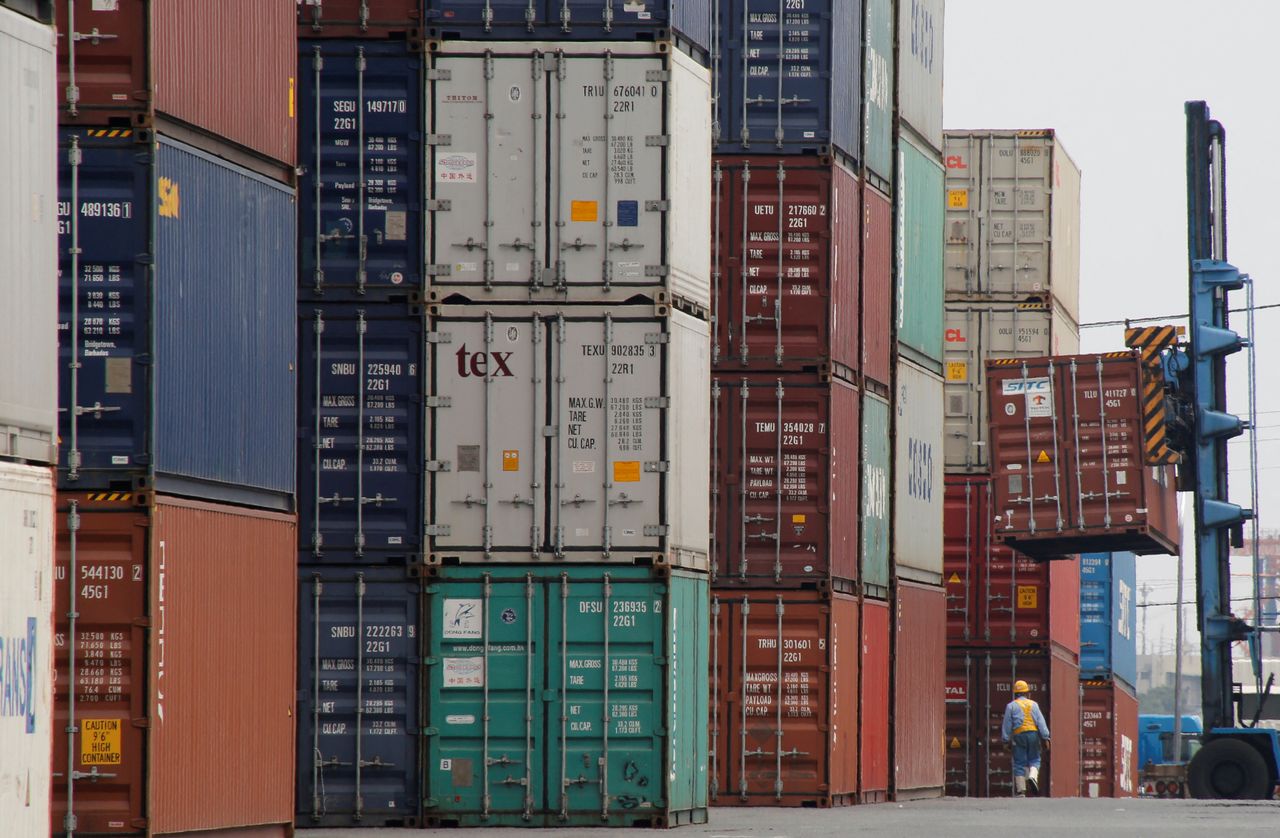 FILE PHOTO: A laborer works in a container area at a port in Tokyo, Japan July 19, 2017. REUTERS/Toru Hanai