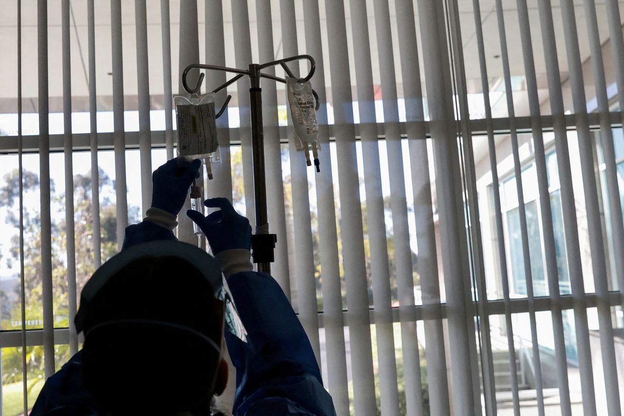 A registered nurse (RN) administers Intravenous Monoclonal Antibody to a coronavirus disease (COVID-19) patient in a respiratory isolation room in the emergency room at Providence Mission Hospital in Mission Viejo, California, U.S., January 27, 2022.  REUTERS/Shannon Stapleton