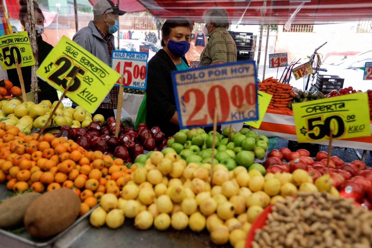 FILE PHOTO: Customers walk past a fruit stall at a street market, in Mexico City, Mexico December 17, 2021. REUTERS/Luis Cortes/File Photo