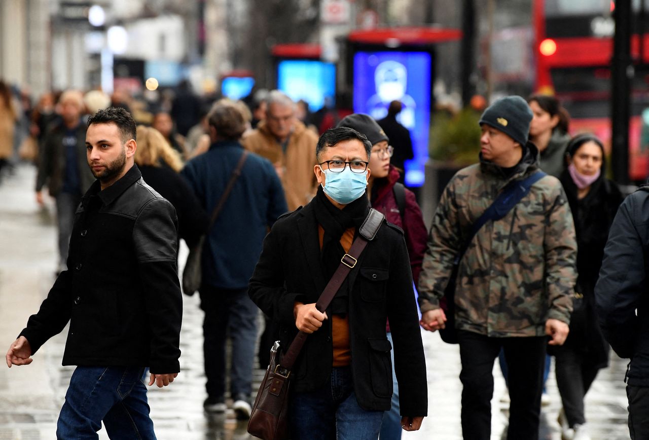 A shopper wearing a protective face mask walks on Oxford Street, as rules on wearing face coverings in some settings in England are relaxed, amid the spread of the coronavirus disease (COVID-19) pandemic, in London, Britain, January 27, 2022. REUTERS/Toby Melville