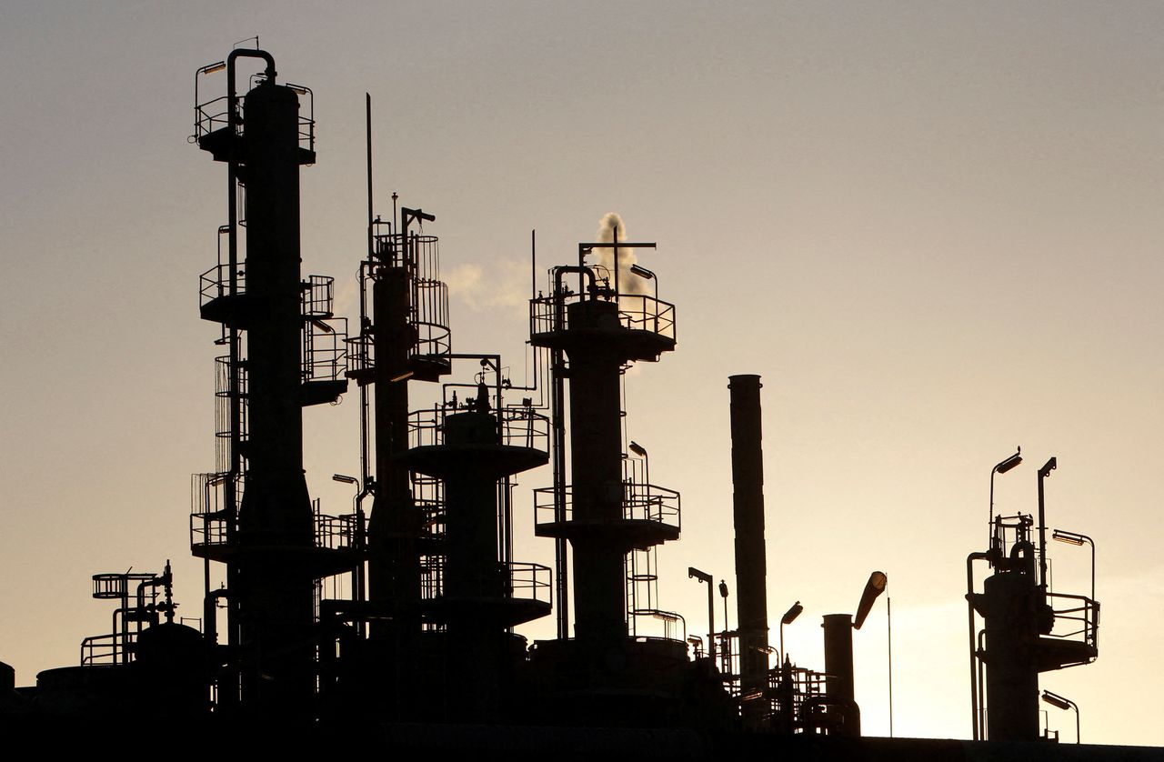 FILE PHOTO: Towers and smokestacks are silhouetted at an oil refinery in Melbourne June 21, 2010.  REUTERS/Mick Tsikas/File Photo