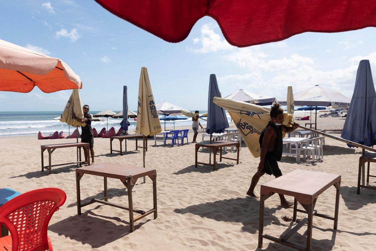 FILE PHOTO: Workers pack up the parasols to close the beach as Indonesia imposes emergency measures, tightening restrictions in Java and Bali as coronavirus disease (COVID-19) cases surge, in Seminyak, Bali, Indonesia, July 3, 2021. REUTERS/Nyimas Laula/File Photo