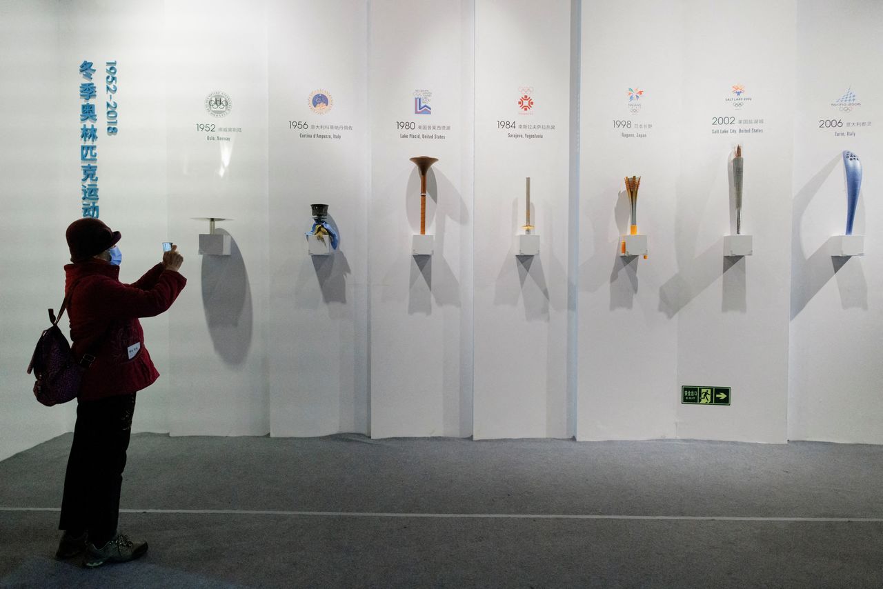 FILE PHOTO: A woman takes pictures of Olympic torches of past Games at an exhibition at the Capital Museum ahead of the Beijing 2022 Winter Olympics in Beijing, China, January 5, 2022.   REUTERS/Thomas Peter