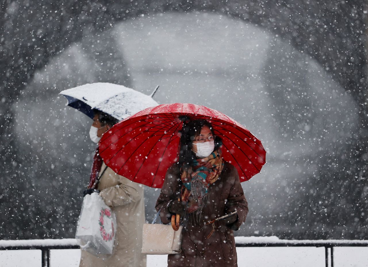 FILE PHOTO: People wearing protective face masks visit the snow-covered Imperial Palace, amid the coronavirus disease (COVID-19) pandemic, in Tokyo, Japan January 6, 2022. REUTERS/Issei Kato