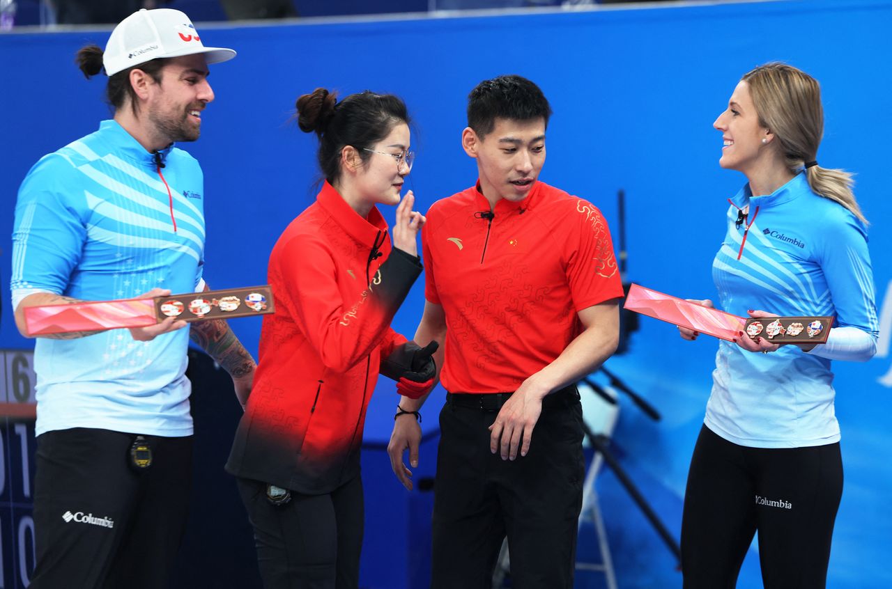 2022 Beijing Olympics - Curling - Mixed Doubles Round Robin Session 8 - China v United States - National Aquatics Center, Beijing, China - February 5, 2022. Christopher Plys of the United States and Victoria Persinger of the United States hold gifts from Ling Zhi of China and Fan Suyuan of China after their match. REUTERS/Evelyn Hockstein