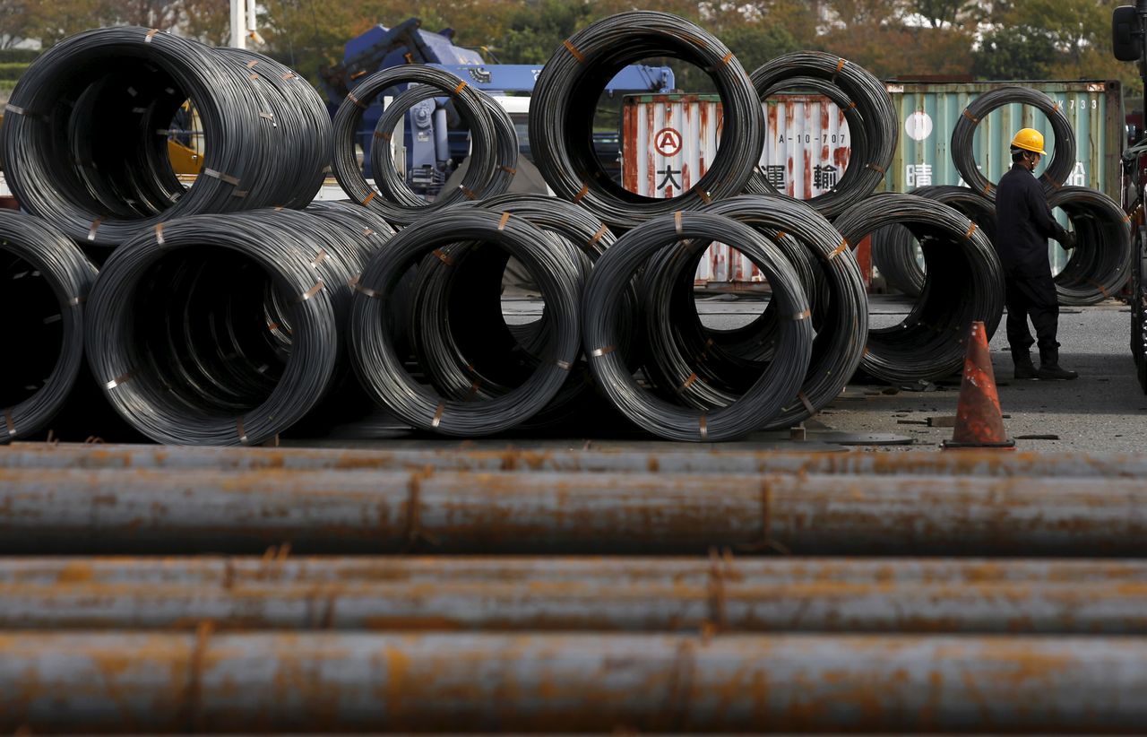 FILE PHOTO: A worker stands near steel coils and steel rods at a steel collection facility in Tokyo, Japan, October 30, 2015. Japanese steelmakers are facing a supply glut, weak orders for drill pipe due to slumping oil prices, and softer-than-expected domestic demand, battering profits and output.  REUTERS/Toru Hanai