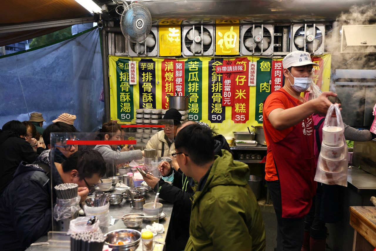 FILE PHOTO: A staff member wearing a protective mask, amid the coronavirus disease (COVID-19) pandemic, serves food in a restaurant at a market in Taipei, Taiwan, January 6, 2021. REUTERS/Ann Wang