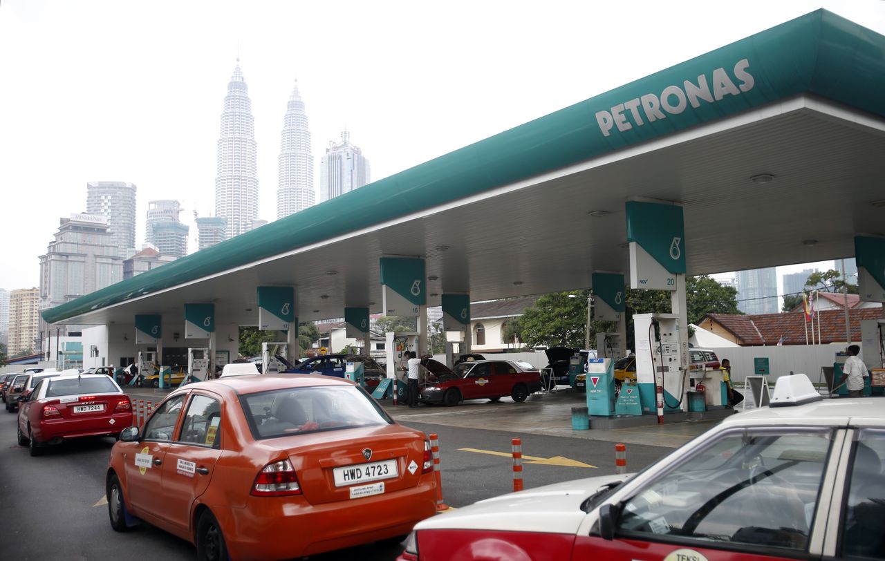 FILE PHOTO: Motorists queue to fill up on natural gas at a Petronas station, with the company