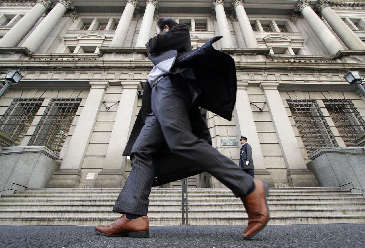 FILE PHOTO: A man walks past the Bank of Japan building in Tokyo March 17, 2010.  REUTERS/Toru Hanai