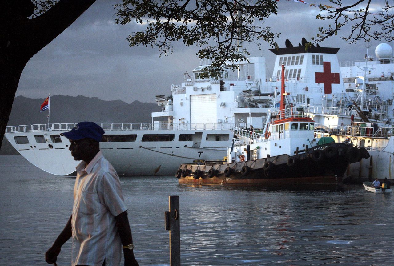 FILE PHOTO: A man walks past a Chinese hospital ship called The Peace Ark, moored in the harbour of the Fiji capital of Suva August 24, 2014.  Picture taken August 24, 2014.  REUTERS/Lincoln Feast/File Photo/File Photo