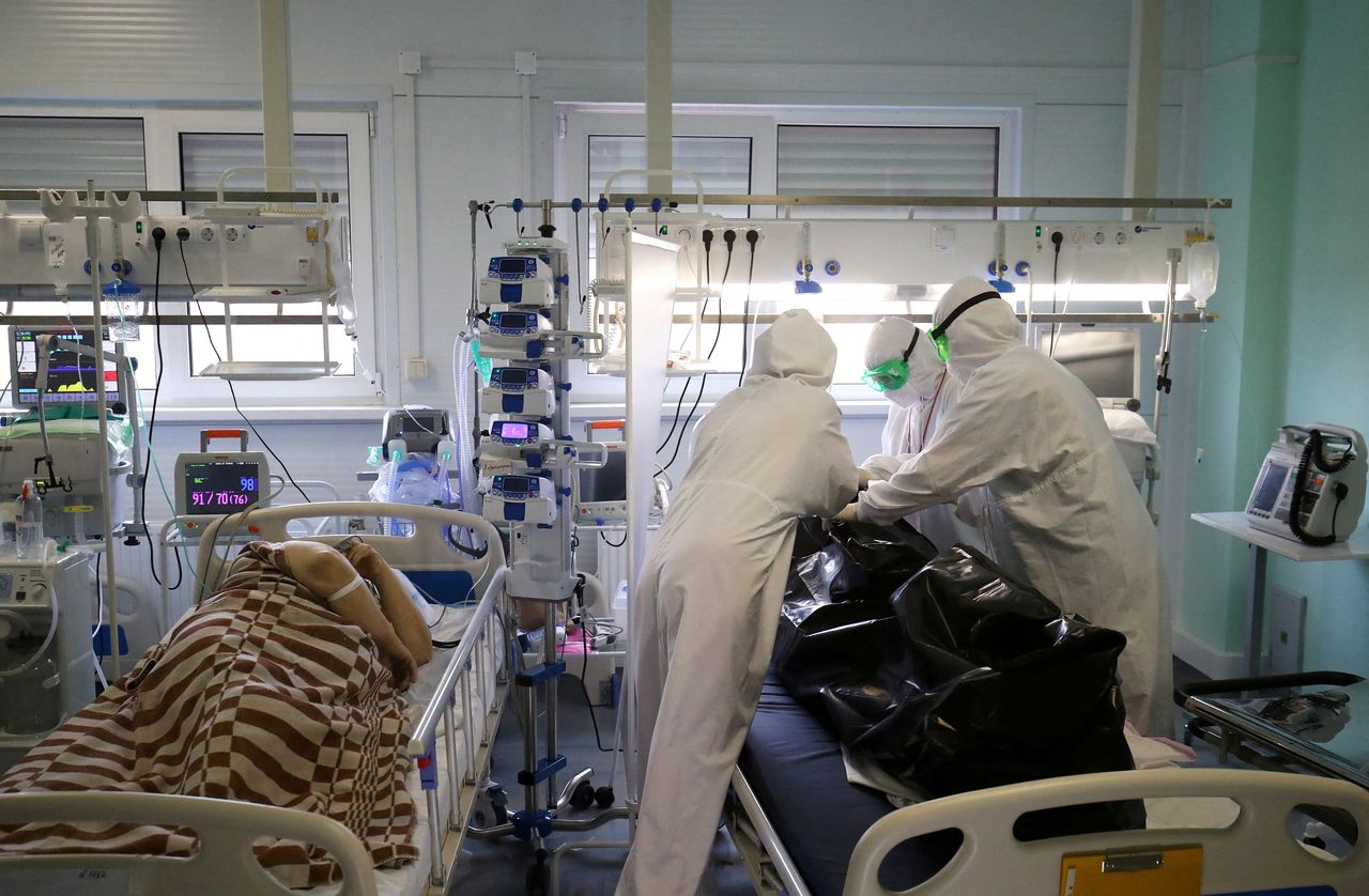 FILE PHOTO: Medical specialists place the body of a person who died at the ICU unit for coronavirus disease (COVID-19) patients in a bag at a local hospital in the town of Kalach-on-Don in Volgograd Region, Russia November 14, 2021. REUTERS/Kirill Braga