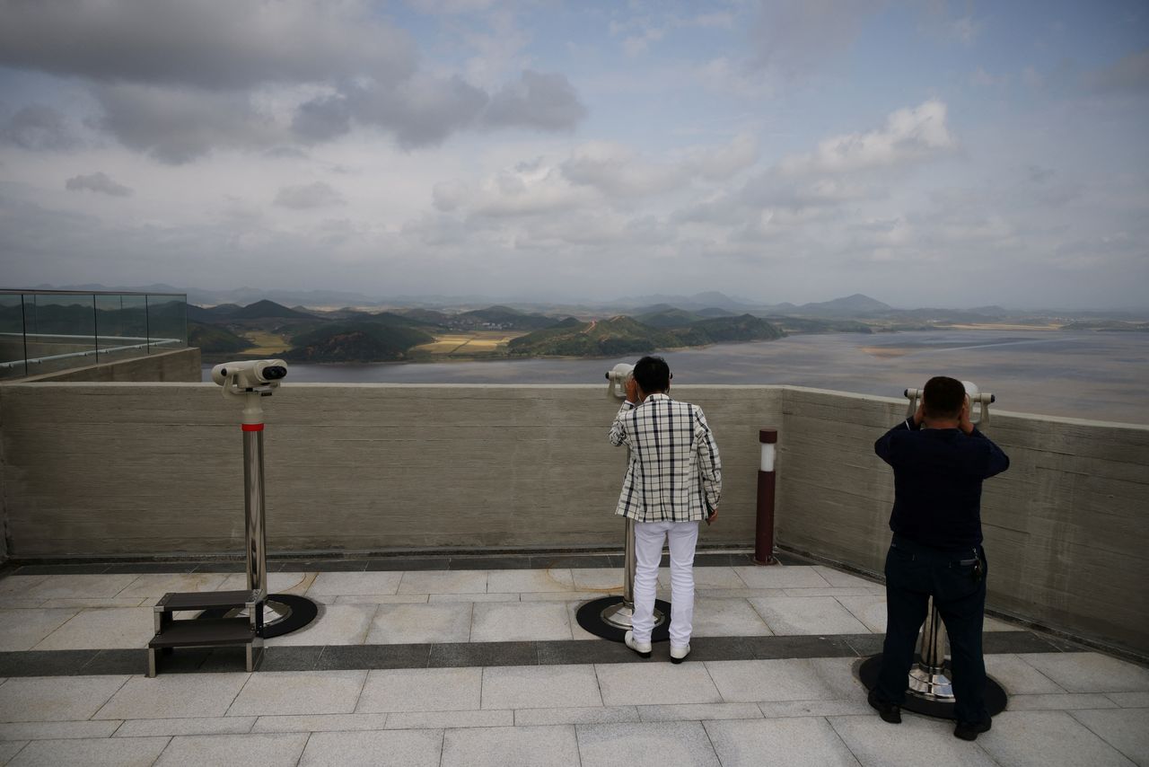 FILE PHOTO: People look at North Korea