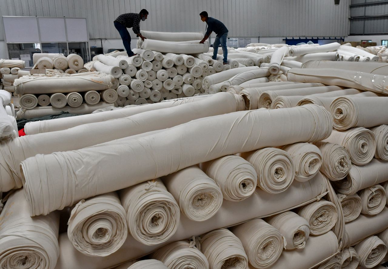 Workers stack rolls of cotton fabric at a textile factory of Texport Industries in the town of Hindupur in the southern state of Andhra Pradesh, India, February 9, 2022. REUTERS/Samuel Rajkumar