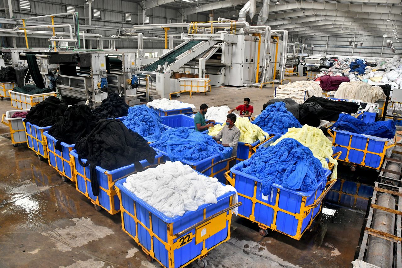 Workers sort washed and dyed clothes piled into carts at a textile factory of Texport Industries in the town of Hindupur in the southern state of Andhra Pradesh, India, February 9, 2022. REUTERS/Samuel Rajkumar